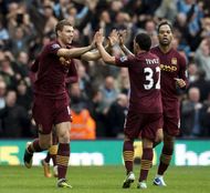 Manchester City's forward Edin Dzeko (L) celebrates with his teammates after scoring
